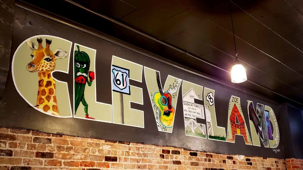 A colorful mural filled with local symbols and characters spells out "Cleveland."
